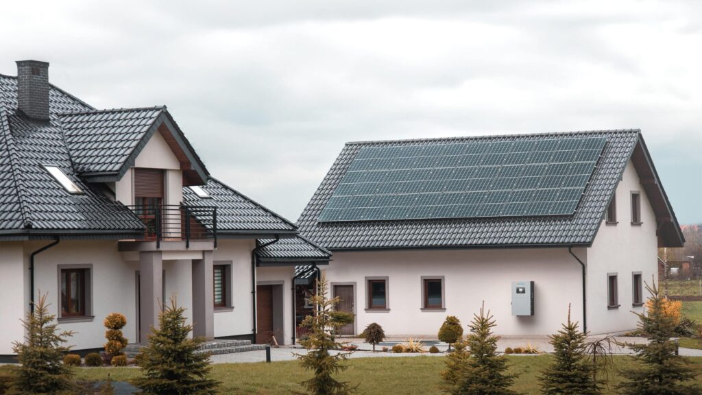 The photo shows an invertor mounted on the side of a garage on an upscale rural property